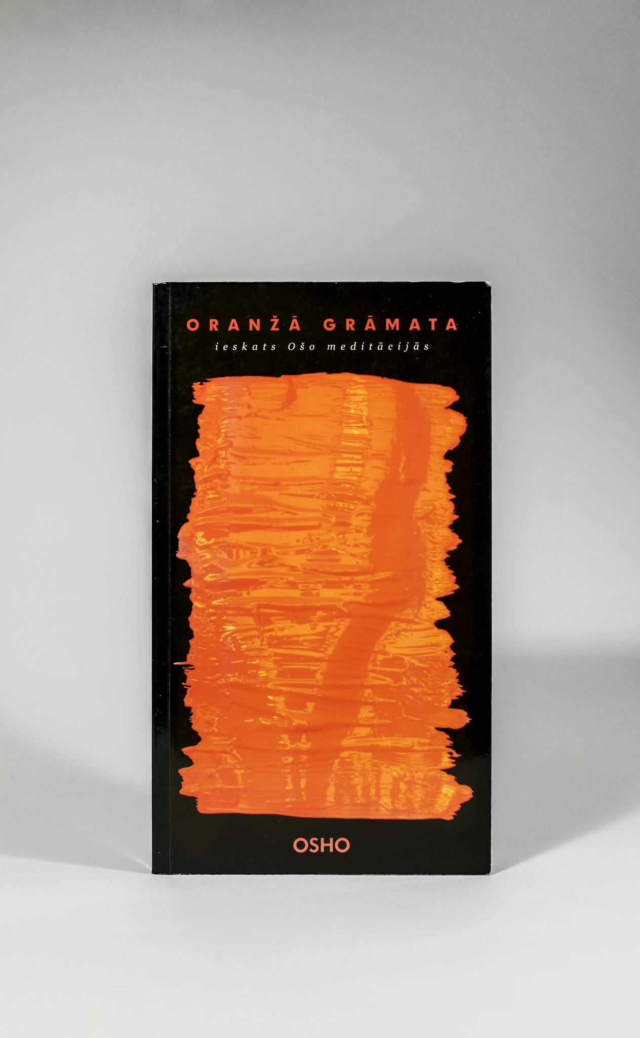 Stylish book cover with a striking orange abstract design on a sleek black background.